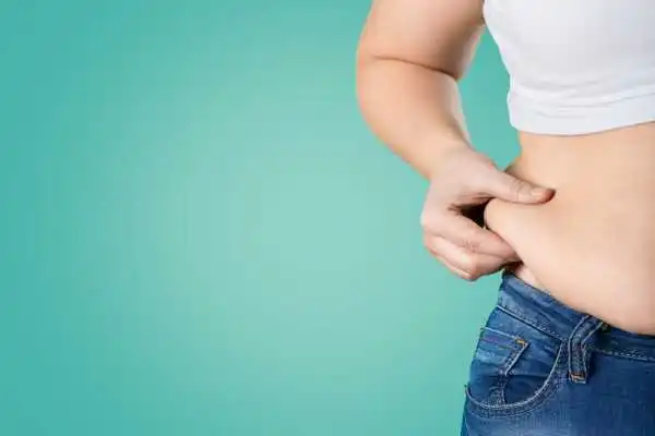 Image of woman pinching her love handles to show weight gain Witney