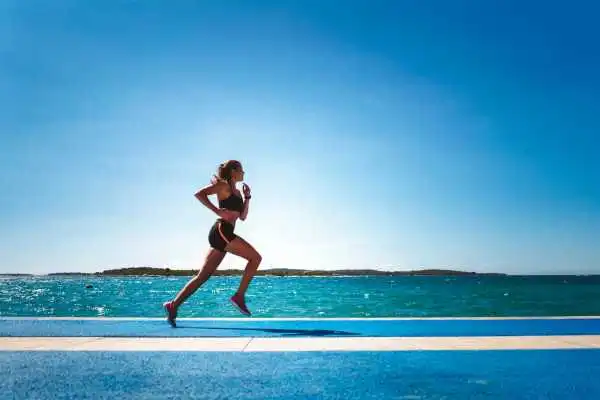Woman running showing strong leg muscle Witney
